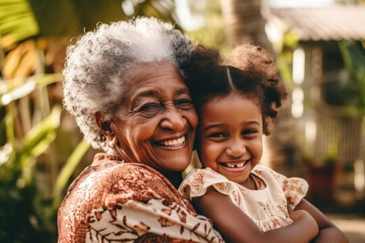 A Black grandmother gently hugging her grandchild outdoors, both smiling with eyes closed, soft natural lighting highlighting their joy and love.