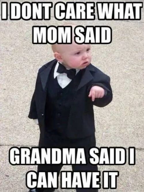 Baby in a tuxedo pointing with text saying Grandma allows it despite Mom’s disapproval.
