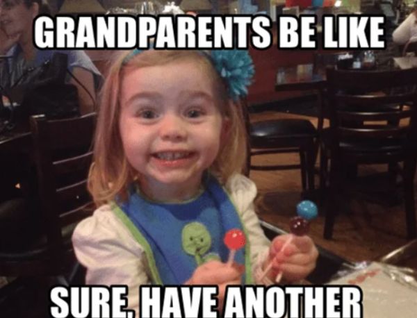 Excited little girl holding two lollipops with text saying grandparents always let kids have more candy.
