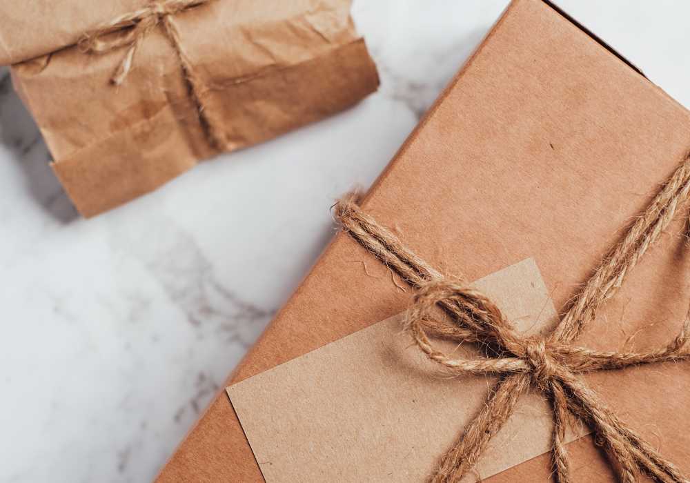 Brown paper-wrapped package tied with twine sits on a marble surface, giving a rustic gift feel.