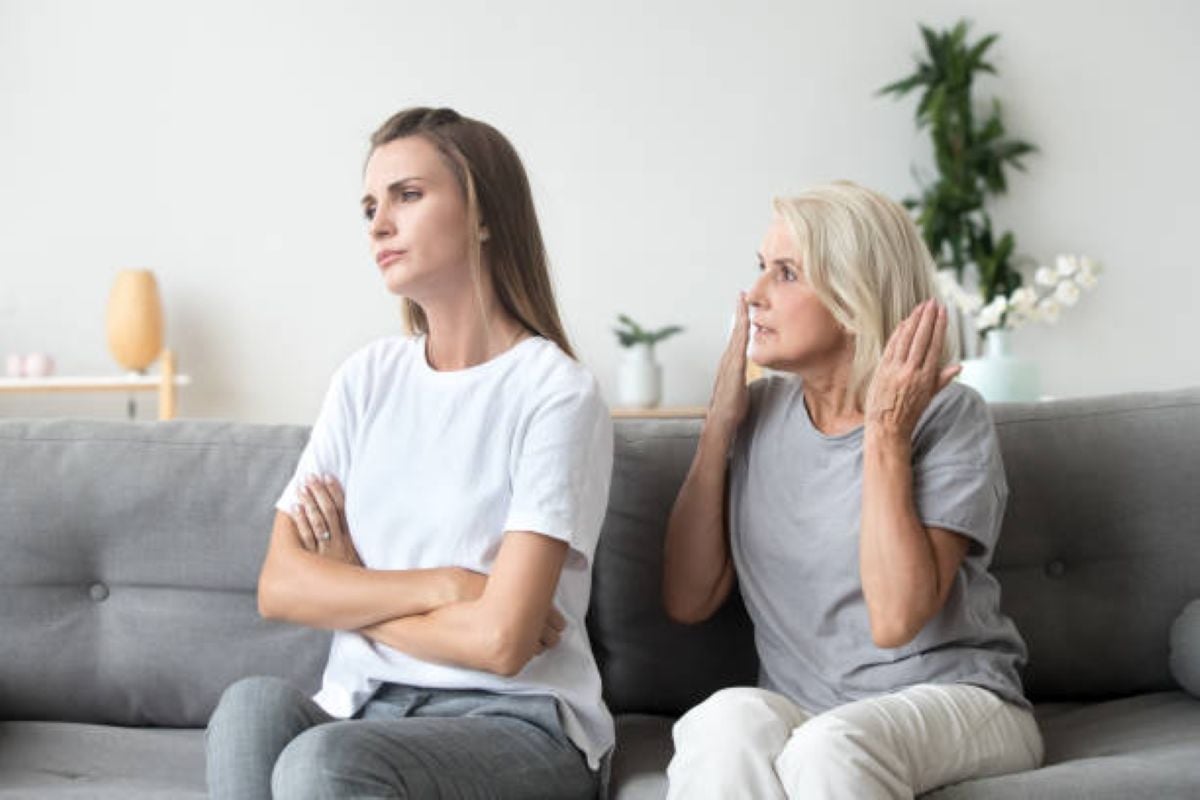 9 Emotional Wounds Adult Children Simply Don’t Realize They’re Inflicting on Their Parents 1 Upset younger woman with arms crossed ignoring older woman during an argument on a couch.