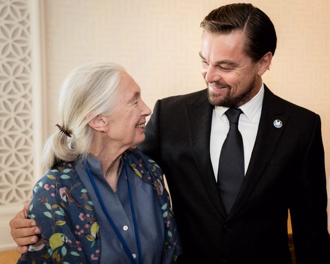 Woman smiling and embracing a suited man in conversation at an event or gathering.