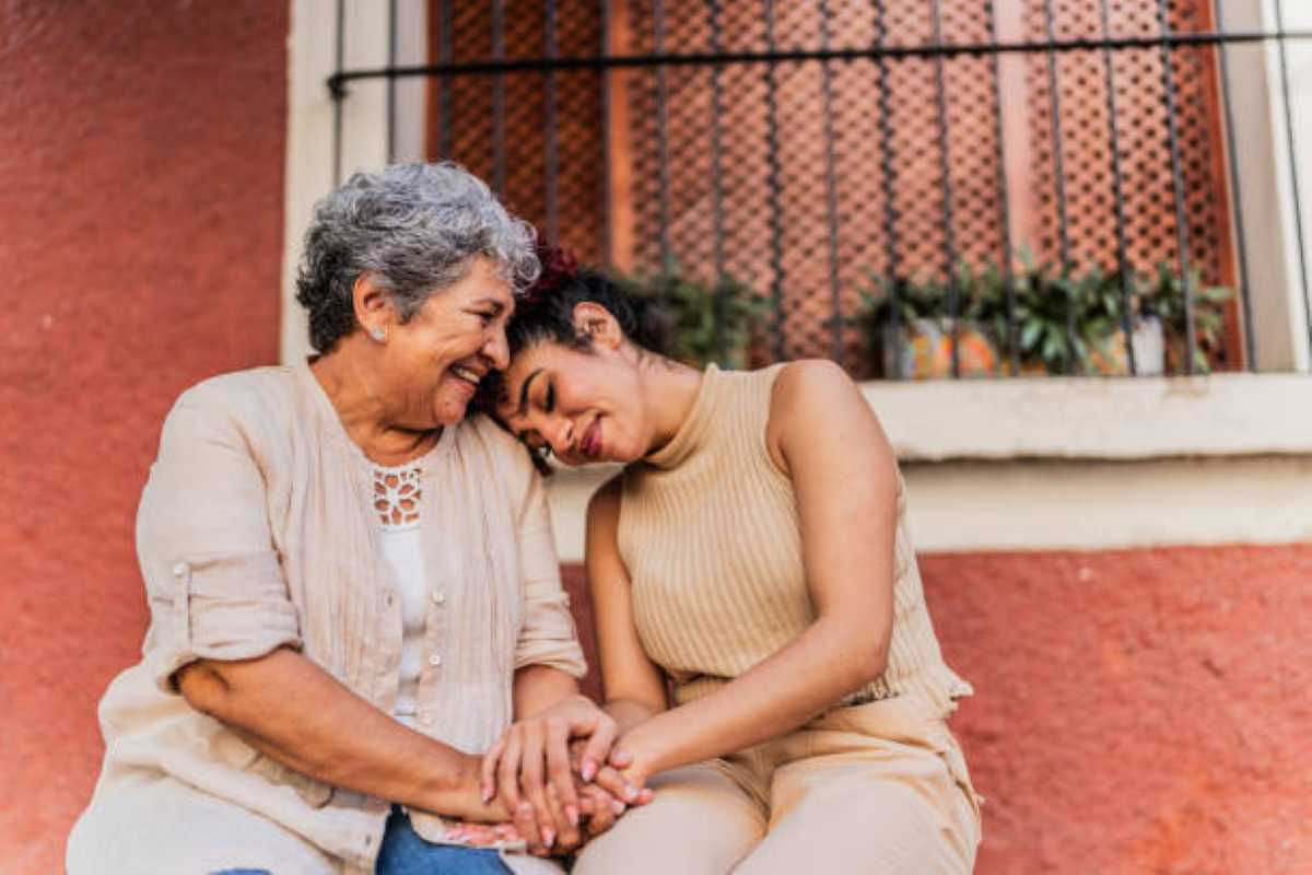 Grandmother and her adult daughter together outdoors.