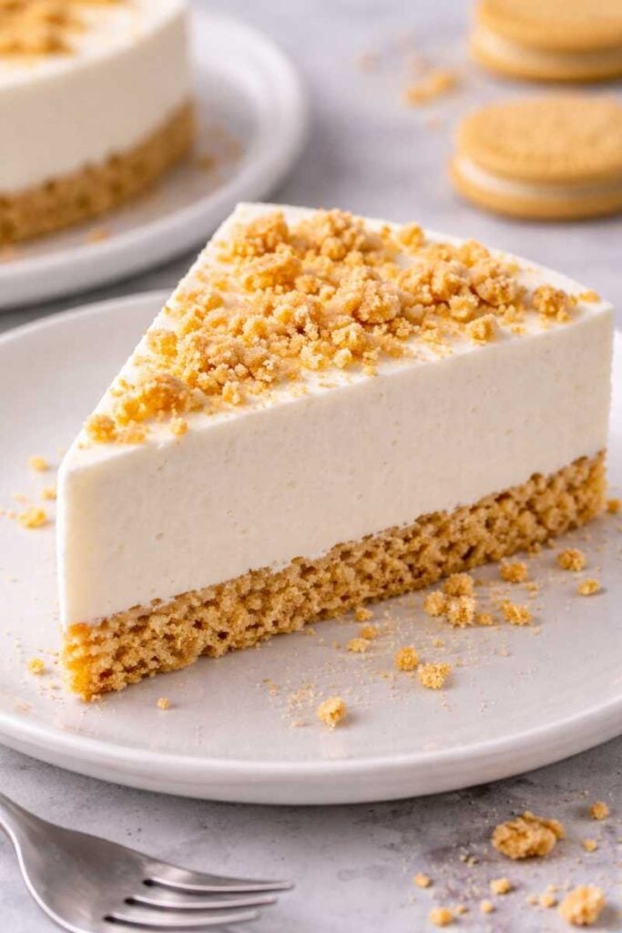 The Best 3-Ingredient Greek Yogurt Cheesecake Recipe Ever (No Bake With Condensed Milk) 5 Slice of no-bake Greek yogurt cheesecake with a vanilla cookie crust and cookie crumb topping on a plate.