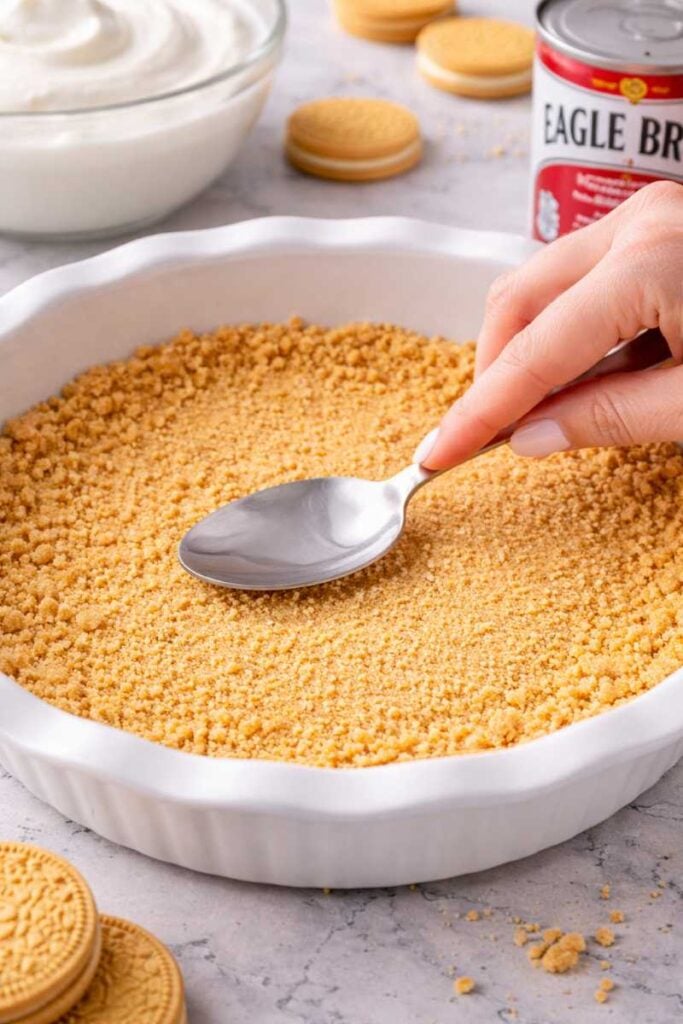 The Best 3-Ingredient Greek Yogurt Cheesecake Recipe Ever (No Bake With Condensed Milk) 3 Crushed vanilla sandwich cookies pressed into a pie dish to form a cheesecake crust.