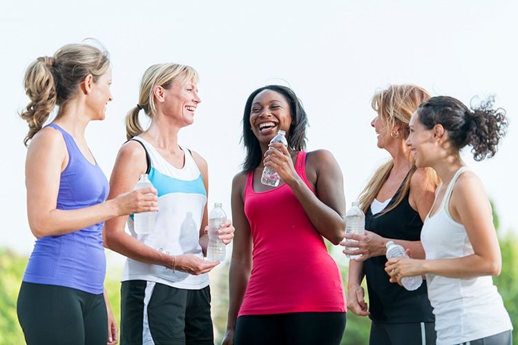People who still look young in their 60s and beyond usually adopt these 8 daily habits 5 Group of women in fitness clothes laughing together while holding water bottles after exercising outdoors.
